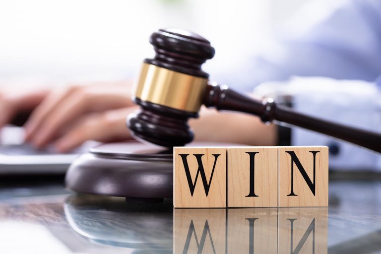 Male Judge In A Courtroom Typing On Laptop - ASK LLP - ASK LLP